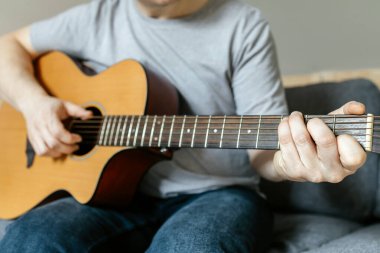 Adam oturur, gitar çalar, akor çalar, çalmayı öğrenir. Yetişkinler için hobiler.