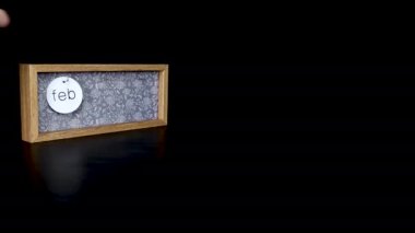 Tahta takvim bloğu, 4 Şubat Kış Olimpiyatları 'nın başlangıç tarihini gösteriyor. Üzerinde tarih ve ay yazılı metal diskleri çıkartan bir adam, 8 bin kalite.