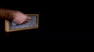 Tahta takvim bloğu 16 Şubat 'ta bir adamın elini takıp üzerinde tarih ve ay yazılı olan metal diskleri çıkardığını gösteriyor.