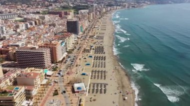 Aerial drone footage of the beautiful beach front of the coastal town of  Fuengirola in Malaga Spain Costa Del Sol, showing the sandy beach, hotels and apartments on a sunny day in the summer time