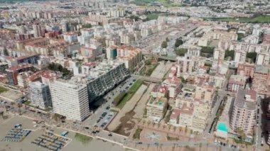 Aerial drone footage of the beautiful beach front of the coastal town of  Fuengirola in Malaga Spain Costa Del Sol, showing the sandy beach, hotels and apartments on a sunny day in the summer time