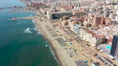 Aerial drone footage of the beautiful beach front of the coastal town of  Fuengirola in Malaga Spain Costa Del Sol, showing the sandy beach, hotels and apartments on a sunny day in the summer time