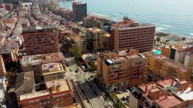 Aerial drone footage of the beautiful beach front of the coastal town of  Fuengirola in Malaga Spain Costa Del Sol, showing the sandy beach, hotels and apartments on a sunny day in the summer time