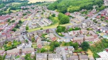 Aerial footage of the town of Batley in Wakefield West Yorkshire UK, showing a typical British housing estates with roads and streets, taken with a drone on a sunny day above the houses.