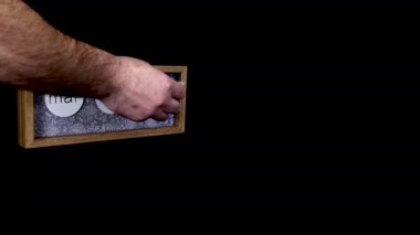 A wooden calendar block showing the date March 4th with a mans hand putting on and taking off the metal discs with the date and month on them, filmed in 8k quality