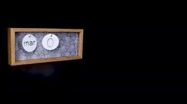 A wooden calendar block showing the date March 5th with a mans hand putting on and taking off the metal discs with the date and month on them, filmed in 8k quality