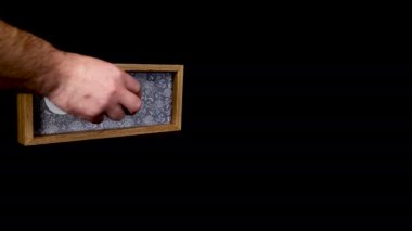 A wooden calendar block showing the date March 8th with a mans hand putting on and taking off the metal discs with the date and month on them, filmed in 8k quality