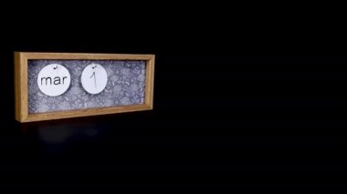 A wooden calendar block showing the date March 18th with a mans hand putting on and taking off the metal discs with the date and month on them, filmed in 8k quality