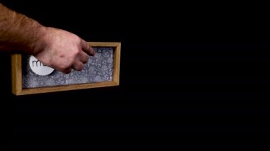 A wooden calendar block showing the date March 23rd with a mans hand putting on and taking off the metal discs with the date and month on them, filmed in 8k quality