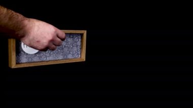 A wooden calendar block showing the date March 28th with a mans hand putting on and taking off the metal discs with the date and month on them, filmed in 8k quality