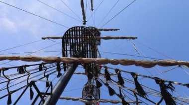 Footage looking straight up on a pirate ship showing the crows nest and wooden beams on a bright sunny summers day, filmed in 8k footage quality.