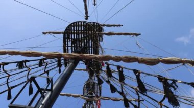 Footage looking straight up on a pirate ship showing the crows nest and wooden beams on a bright sunny summers day, filmed in 8k footage quality.