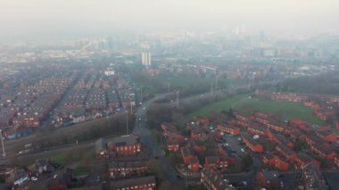 Foggy rainy aerial drone footage of the town centre of Leeds, West Yorkshire in the UK, showing a birds eye view of the city centre on a cold foggy winters day