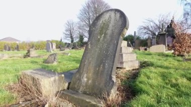 Footage of a cemetery graveyard on a foggy winters day, taken with a drone showing the very old Headstones or  grave stones and bare winters trees, in the town of Leeds West Yorkshire in the UK