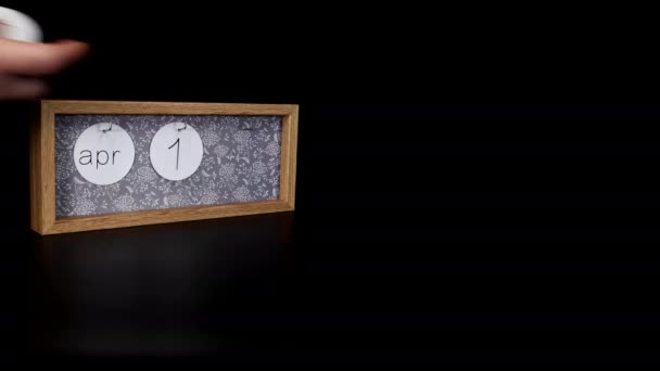 4月10日 一个印有日期的木制日历块 上面印有日期和月份 上面有一个男人手拿起金属盘 质量为8K — 图库视频影像