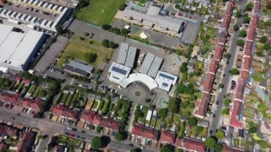 Aerial drone footage of the the large suburb of Wembley  in north-west London in the UK, showing the residential streets and suburban houses on a hot sunny day in the summer time.