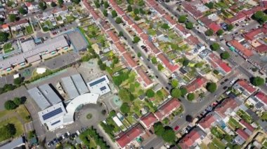 Aerial drone footage of the the large suburb of Wembley  in north-west London in the UK, showing the residential streets and suburban houses on a hot sunny day in the summer time.