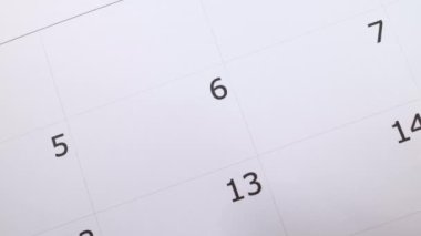 A calendar showing the number 6 with a males hand circling the date with a red pen, save the date or appointment reminder concept.