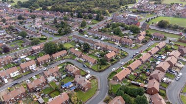 Aerial drone photo of the village of Sharlston and Sharlston Common in Wakefield in the UK, showing the residential housing estates of the village on a sunny day in the summer time.