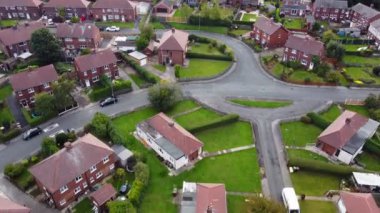 Aerial drone footage of the village of Sharlston and Sharlston Common in Wakefield in the UK, showing the residential housing estates of the village on a sunny day in the summer time.