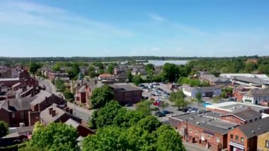 Leeds Batı Yorkshire 'daki Rothwell şehir merkezinin hava görüntülerinde alışveriş merkezleri, itfaiye ve konut alanları parlak güneşli bir yaz gününde arka planda çiftçi tarlaları görülüyor.