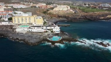 Costa Adeje, Santa Cruz de Tenerife 'nin güzel hava aracı görüntüleri okyanus kıyısında terk edilmiş eski yüzme havuzunu ve Playa de Ajabo plajını gösteriyor..