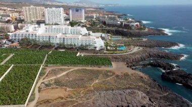 Costa Adeje, Santa Cruz de Tenerife, İspanya 'nın ünlü oteli Riu Buenavistal' ın yaz mevsiminde bir muz çiftliğinin yanında görüntülendiği hava aracı görüntüleri..