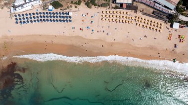 Portekiz 'in Albufeira şehrinin havadan çekilmiş fotoğrafı Praia Santa Eullia plajını ve sıcak yaz günlerinde insanların plajda dinlenmelerini gösteriyor.