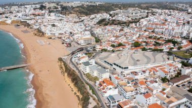 Portekiz 'in Albufeira şehrindeki güzel Albufeira şehrinin havadan çekilmiş fotoğrafı Praia de Albufeira altın kumlu plajını gösteriyor..