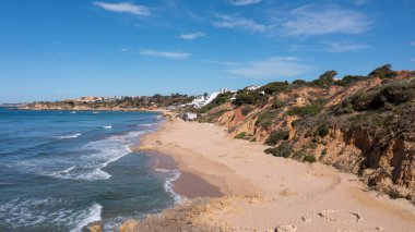 Portekiz 'in Albufeira şehrindeki güzel plajın havadan çekilmiş fotoğrafı sıcak bir yaz gününde okyanus kıyısında tenha bir sahili gösteriyor..