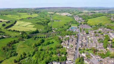 İngiltere 'nin batı Yorkshire kentindeki Bradford şehrinin metropoliten ilçesi içinde yaz mevsiminde köy ve viyadüklerin görüldüğü Thornton kasabasının insansız hava aracı görüntüleri..