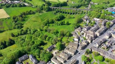 İngiltere 'nin batı Yorkshire kentindeki Bradford şehrinin metropoliten ilçesi içinde yaz mevsiminde köy ve viyadüklerin görüldüğü Thornton kasabasının insansız hava aracı görüntüleri..