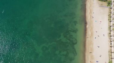 İbiza 'daki güzel Sant Antoni de Portmany köyünün havadan çekilmiş görüntüleri. Güneşli bir yaz gününde sahilde insanlarla birlikte sahili gösteriyor..