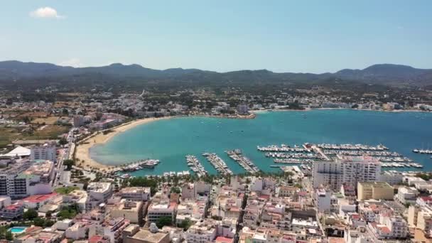 西班牙巴利阿里群岛Ibiza岛上Sant Antoni村海滩的无人驾驶飞机镜头 显示正在划船的港口和Ibiza称为Playa San Antonio的海滩 — 图库视频影像