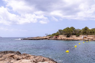 Ibiza 'nın batı kıyısındaki Sant Antoni de Portmany' nin sahili önünde çekilmiş bir fotoğraf. Spains Balear Adalarından biri. Yazın okyanus önünü ve kayaları gösteriyor.