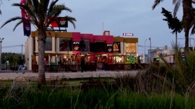 Sant Antoni de Portmany, İbiza, 24 Mayıs 2023: İspanya 'nın İbiza kentindeki Sant Antoni de Portmany kasabasının akşam saatlerinde KFC ve Pizza Hut restoranını gösteren görüntüleri