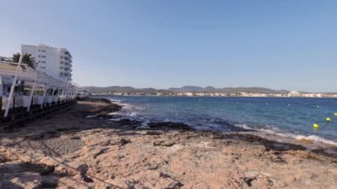 İspanya 'nın Balear Adaları' ndaki İbiza adasındaki Sant Antoni de Portmany kasabasından deniz manzarası ve plaj manzarasını gösteren bir görüntü..