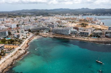 İbiza Balearic Adaları 'ndaki Sant Antoni de Portmany kasabasındaki bir kumsalın insansız hava aracı fotoğrafı İspanya' nın okyanus cephesini ve Cala Alto de Porta plajını gösteriyor..