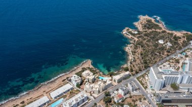 İbiza Balearic Adaları 'ndaki Sant Antoni de Portmany kasabasındaki bir kumsalın insansız hava aracı fotoğrafı İspanya' nın okyanus cephesini ve Cala Alto de Porta plajını gösteriyor..