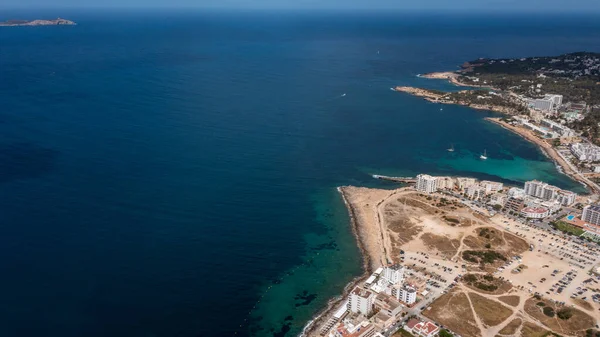 İbiza Balearic Adaları 'ndaki Sant Antoni de Portmany kasabasındaki bir kumsalın insansız hava aracı fotoğrafı İspanya' nın okyanus cephesini ve Cala Alto de Porta plajını gösteriyor..