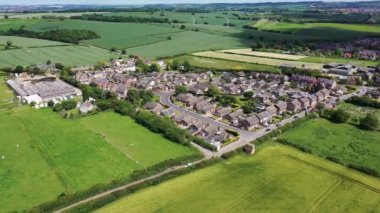 İngiltere 'nin güneyindeki Barnsley Metropolitan Borough' daki Great Houghton köyünün güneşli bir yaz gününde güzel bir köy ve çiftçi tarlalarını gösteren insansız hava aracı görüntüleri..