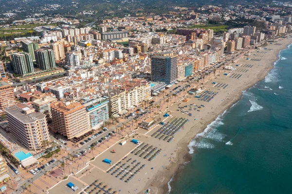 İspanya 'nın Malaga kıyı kasabası Fuengirola' nın önündeki güzel sahil insansız hava aracı fotoğrafı, güneşli bir yaz gününde kumlu sahil, otel ve daireleri gösteriyor.