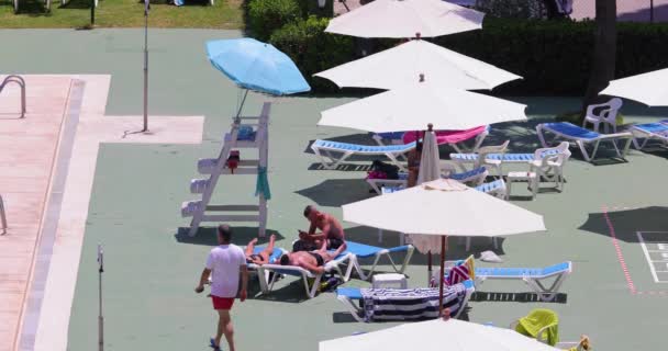 西班牙贝尼多姆 2023年7月1日 夏季阳光明媚的一天 西班牙美丽的贝尼多姆市的景象 人们在宾馆游泳池边的日光浴中放松下来 — 图库视频影像