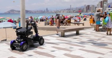 Benidorm İspanya, 1 Temmuz 2023: İspanya 'nın güzel şehri Benidorm' un plajında plajda hareketli bir scooterla sahile park etmiş.