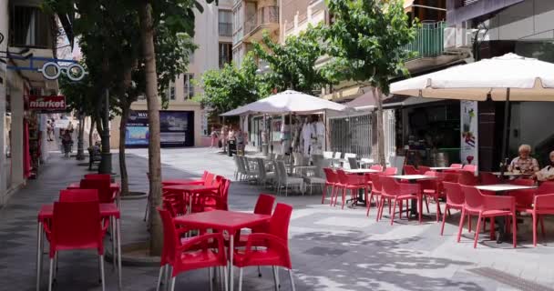 スペイン ベニドルム 2023年7月1日 スペインの美しい都市ベニドルムの映像は 夏の時間に外のテーブルを持つレストランで旧市街の通りを歩いている人々を示しています — ストック動画