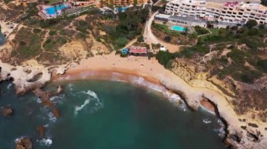Portekiz 'deki Albufeira' nın güzel plajının hava görüntüleri, Praia dos Aveiros 'un küçük özel plajını gösteriyor. Dalgalar altın kumlu plajlara çarpıyor ve etrafını kayalıklarla çeviriyor..