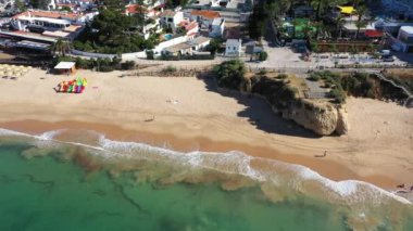 Portekiz 'deki Albufeira sahilinin hava görüntüleri Praia de Albufeira ve Praia da Oura Sahili' ni ve güneşli bir yaz gününde kumsallara vuran dalgaları gösteriyor.
