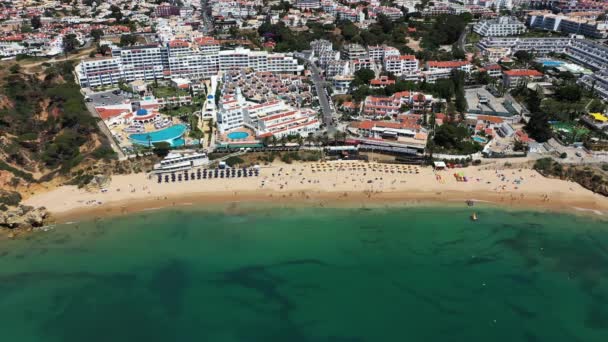 ポルトガルのアルブフェイラの美しいビーチフロントの航空映像 プラヤ ビーチと晴れた夏の日に黄金の砂浜に衝突する波を示しています — ストック動画