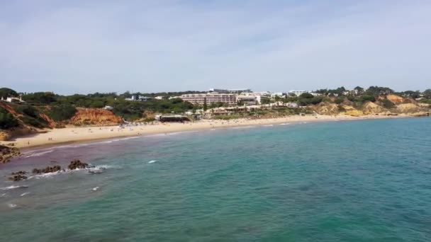 ポルトガルのアルブフェイラの美しいビーチフロントの航空映像 プラリア オラビーチと晴れた夏の日に黄金の砂浜に衝突する波を示しています — ストック動画