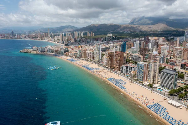 stock image Aerial drone photo of the beautiful city of Benidorm in Spain in the summer time showing the Playa de Levante beach and the high rise apartments and hotels in the city in the summer time